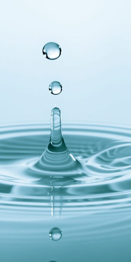 Splash of water droplets on&nbsp;a&nbsp;smooth water surface